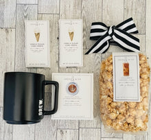 Load image into Gallery viewer, black &#39;BREW.&#39; coffee mug, cold brew caramel popcorn,  two mini sugar cookies, Columbian medium roast pour over coffee gift set. Packaged in black box with black and white bow
